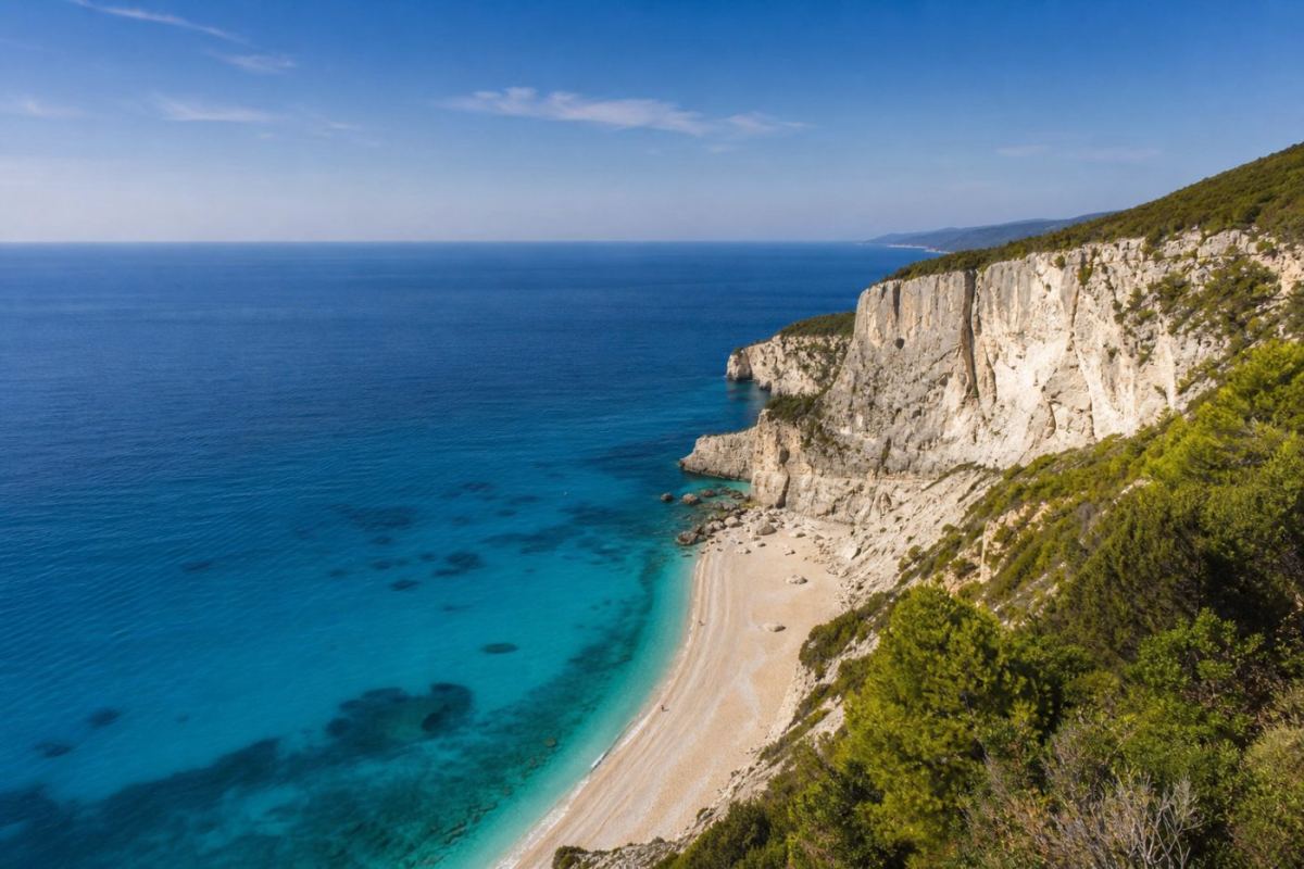 Vit klippstrand med turkost vatten på Lefkas västkust i sommarsol