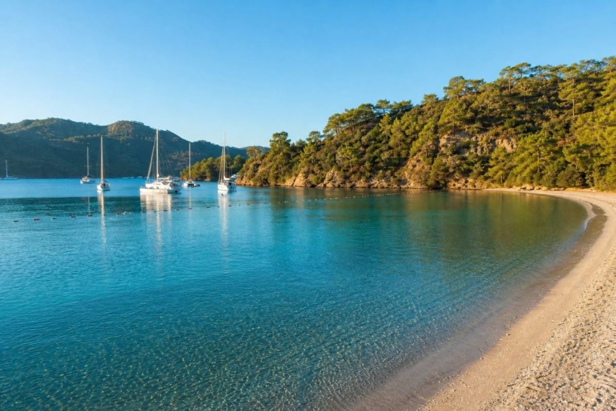 Skyddad turkos vik vid Marmaris med segelbåtar i en lugn hamn och gröna kullar i bakgrunden