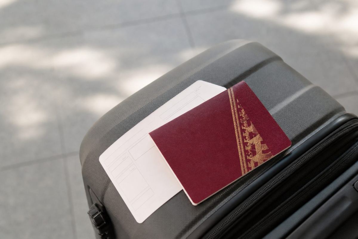 Ett pass och ett boardingkort som ligger på en resväska inför en utlandsresa