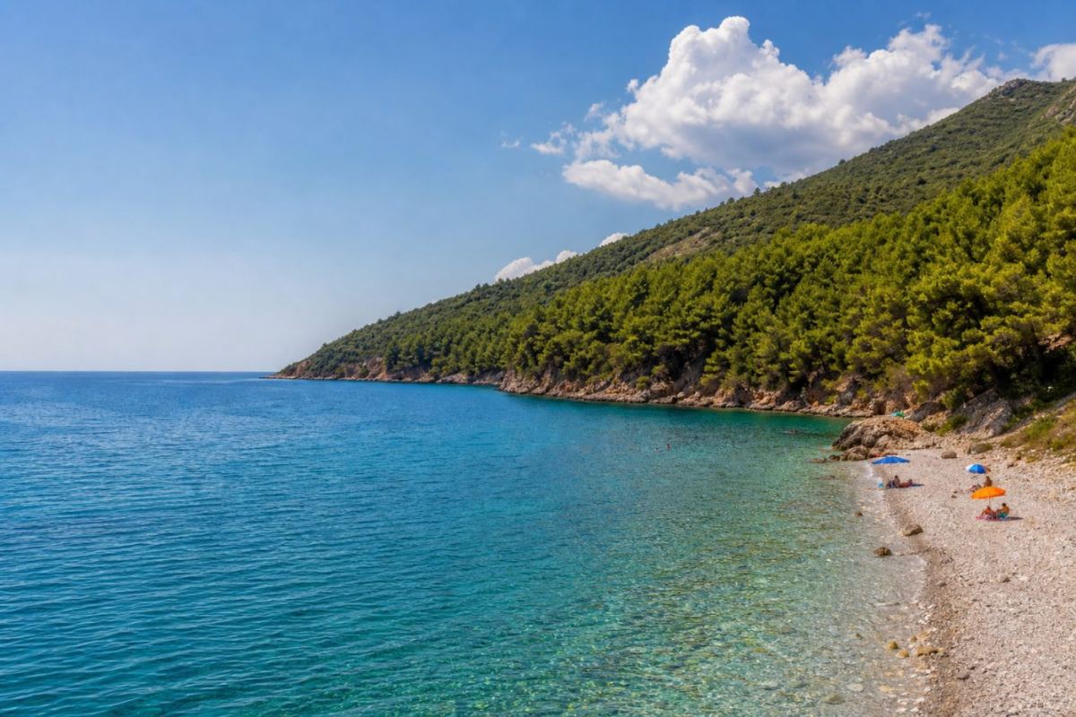 Solig vik på Samos med pinjeklädda berg och turkost vatten